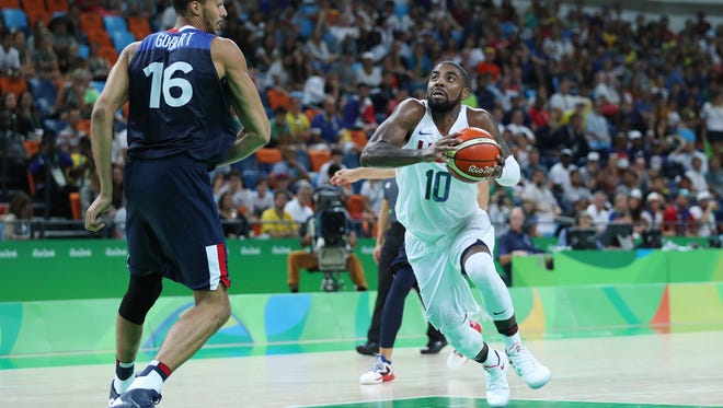United States guard Kyrie Irving drives to the basket against France center Rudy Gobert during the men's preliminary round in the Rio 2016 Summer Olympic Games at Carioca Arena 1.