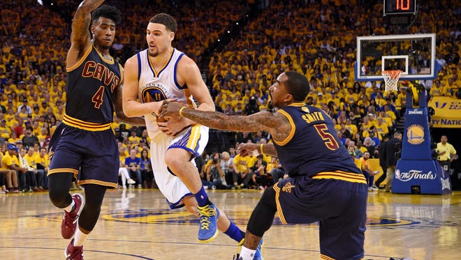 Golden State Warriors guard Klay Thompson (11) drives to the basket against Cleveland Cavaliers guard Iman Shumpert (4) and Cleveland Cavaliers guard J.R. Smith (5) during the third quarter in Game 2.