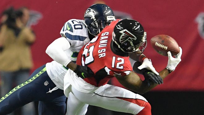 Atlanta Falcons wide receiver Mohamed Sanu (12) makes a catch against Seattle Seahawks cornerback Jeremy Lane (20) during the second quarter in the NFC Divisional playoff at Georgia Dome.