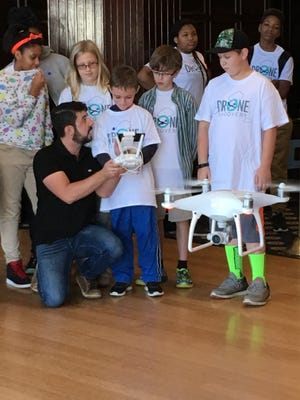 Edward Kostakis, a senior pilot at DJI, hands the controls to a Phantom 4 drone to Duncan Beall, 9, of West Friendship, Md., during the 4-H National Youth Science Day on Oct. 5, 2016, at the National Press Club in Washington, D.C.