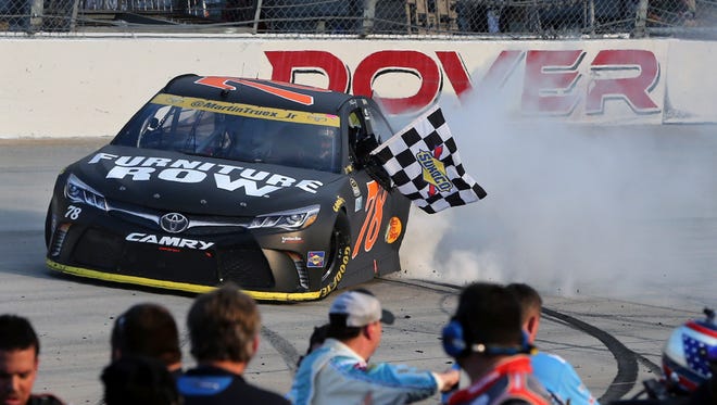 Round 1: Martin Truex Jr. holds the checkered flag as he does a burnout after winning Oct. 2 at Dover International Speedway.