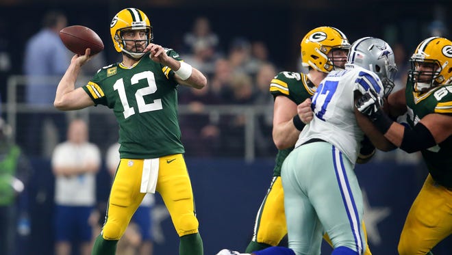 Green Bay Packers quarterback Aaron Rodgers (12) throws a pass during the second quarter against the Dallas Cowboys in the NFC Divisional playoff game at AT&T Stadium.