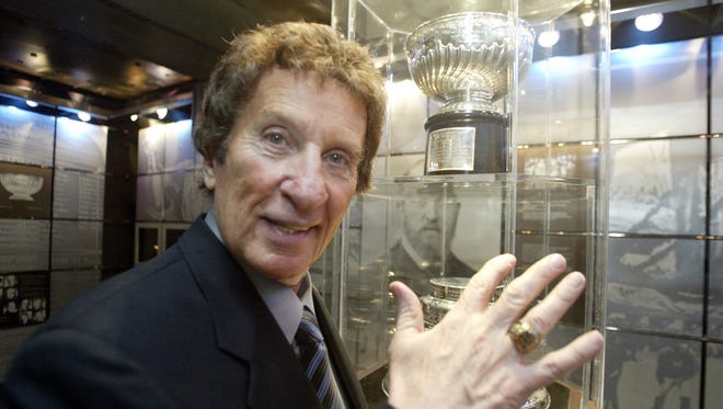 In Nov. 2003,  Detroit Red Wings owner Mike Ilitch shows off his Hockey Hall of Fame ring in the Great Hall with the original Stanley Cup in the background in Toronto.