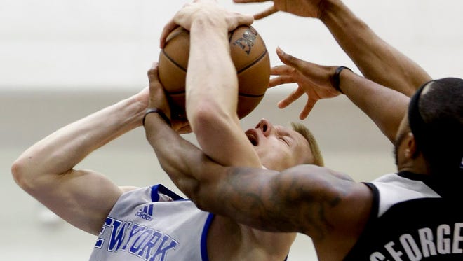 New York Knicks' Ognjen Jaramaz is fouled by Orlando Magic's Marcus Georges-Hunt as he goes to the basket during the first half of an NBA Summer League game in Orlando.