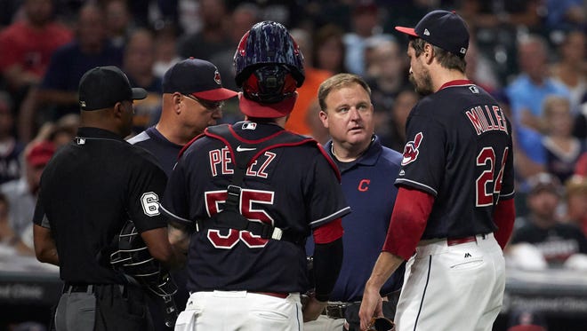 Indians reliever Andrew Miller is checked by, from left to right, umpire Alan Porter, manager Terry Francona, catcher Roberto Perez and a team trainer before leaving the game in the seventh inning with an injury against the Red Sox at Progressive Field. Mandatory Credit: Rick Osentoski-USA TODAY Sports