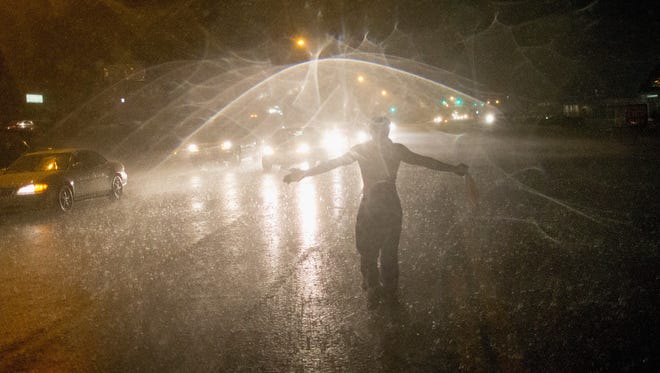Demonstrators march along West Florissant Street in the rain on Aug. 9, 2015, to mark the one-year anniversary of Michael Brown's death in Ferguson, Mo.