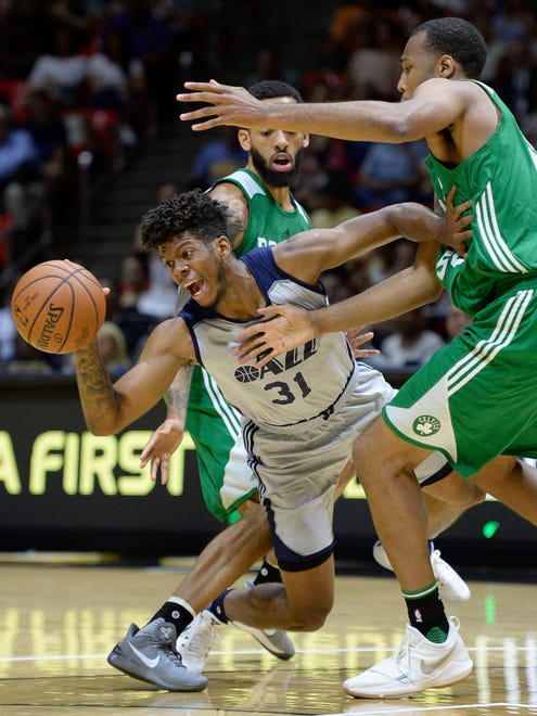Utah Jazz's Tyrone Wallace gets squeezed by Boston Celtics' Terran Petteway and Trevor Thompson during an NBA Summer League game in Salt Lake City.