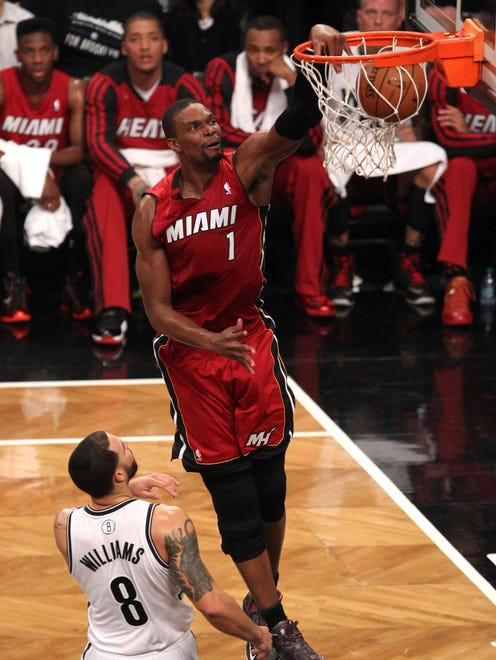 May 12, 2014; Brooklyn, NY, USA; Miami Heat center Chris Bosh (1) dunks against Brooklyn Nets guard Deron Williams (8) in the first half  in game four of the second round of the 2014 NBA Playoffs at the Barclays Center.