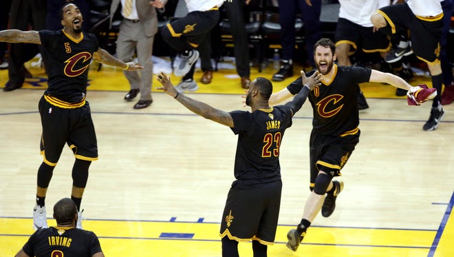 Cleveland Cavaliers forward LeBron James (23) celebrates with Cleveland Cavaliers guard J.R. Smith (5) and Cleveland Cavaliers forward Kevin Love (0) after beating the Golden State Warriors in Game 7.