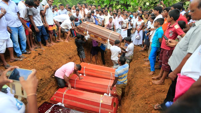 Sri Lankan villagers prepare to bury victims of a landslide at a cemetery in Bellana village, in Kalutara district in, Sri Lanka, Saturday, May 27, 2017. Sri Lanka has appealed for outside help as dozens were killed in floods and mudslides and dozens others went missing.