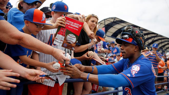 New York Mets' Curtis Granderson signs autographs for fans before the start of an exhibition spring training baseball game against the New York Yankees, Wednesday, March 9, 2016, in Port St. Lucie, Fla.