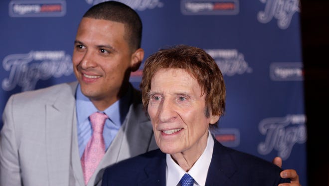 Detroit Tigers designated hitter Victor Martinez stands with team owner Mike Ilitch, Friday, Nov. 14, 2014 in Detroit, after agreeing to terms on a four-year contract through the 2018 season.