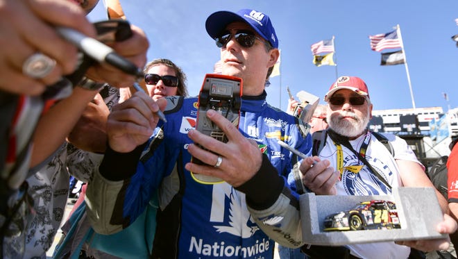 Jeff Gordon signs autographs before practice for the Goody's Fast Relief 500 at Martinsville Speedway.