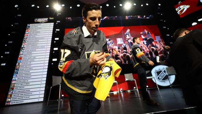 Marc-Andre Fleury signs an autograph on Penguins memorabilia after being selected by the Vegas Golden Knights during the expansion draft.