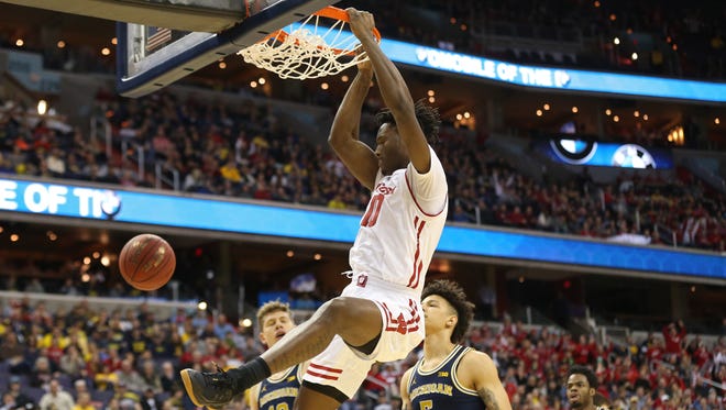Wisconsin Badgers forward Nigel Hayes dunks the ball as Michigan Wolverines forward D.J. Wilson looks on in the first half.