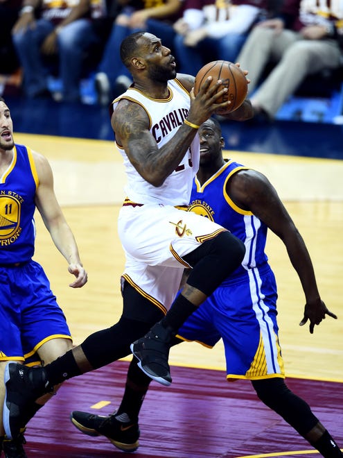 Cleveland Cavaliers forward LeBron James (23) drives to the basket against Golden State Warriors forward Draymond Green (23) during the first quarter in Game 3 of the NBA Finals at Quicken Loans Arena.
