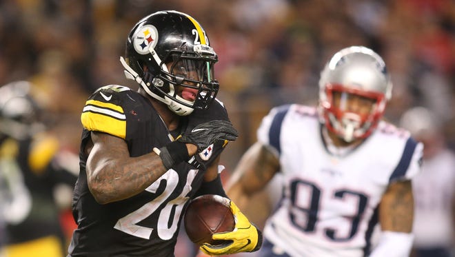 Pittsburgh Steelers running back Le'Veon Bell (26) rushes the ball as New England Patriots defensive end Jabaal Sheard (93) chases during the fourth quarter at Heinz Field.