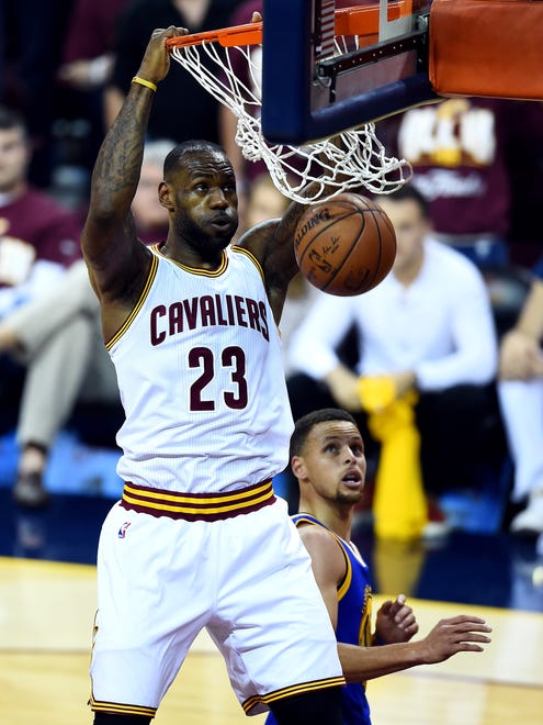 Cleveland Cavaliers forward LeBron James (23) dunks the ball against Golden State Warriors guard Stephen Curry (30) during the first quarter in Game 3 of the NBA Finals at Quicken Loans Arena.