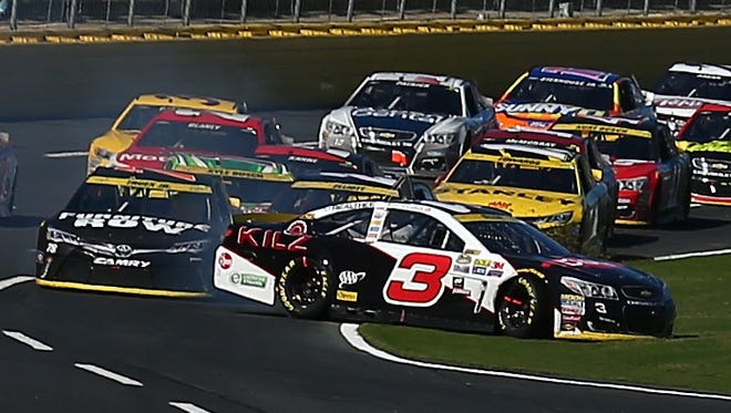 Round 2: Austin Dillon is bumped onto the grass by Martin Truex Jr. during a restart at Charlotte Motor Speedway on Oct. 9.