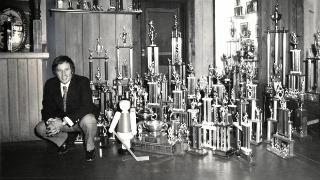 Little Caesar's owner Mike Ilitch with trophies won by teams he sponsors circa 1976.