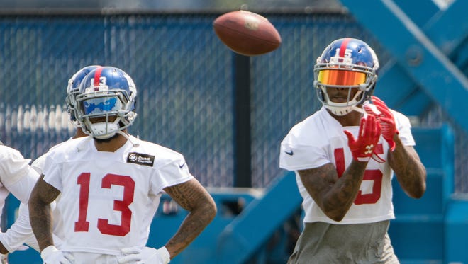 New York Giants wide receiver Odell Beckham (13) looks on as New York Giants wide receiver Brandon Marshall (15) catches the ball during mini camp at Quest Diagnostics Training Center.