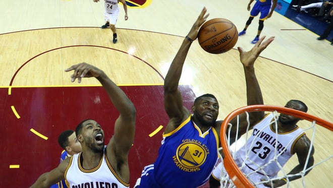 Tristan Thompson and Festus Ezeli go after a rebound in Game 4 of the NBA Finals at Quicken Loans Arena.