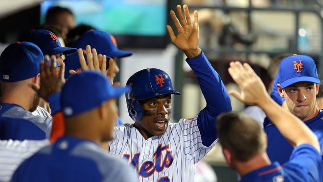 New York Mets left fielder Curtis Granderson (3) celebrates with teammates after scoring on a triple by New York Mets center fielder Juan Lagares (not pictured) against the Chicago Cubs during the sixth inning at Citi Field.