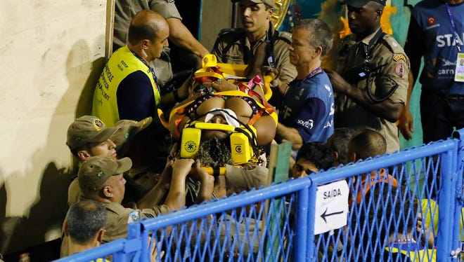 Firefighters carry an injured person to an ambulance during the performing of the Unidos da Tijuca samba school for the Carnival celebrations. Part of a float collapsed during injuring several people.