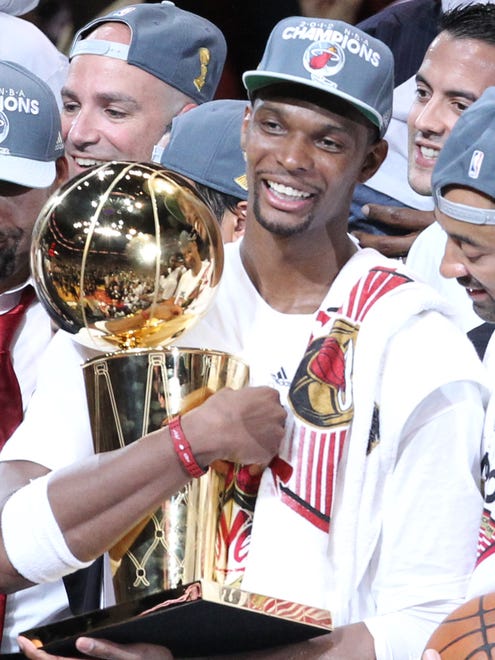Jun 21, 2012; Miami, FL, USA; Miami Heat power forward Chris Bosh (1) celebrates with the Larry O'Brien trophy after winning the 2012 NBA championship at the American Airlines Arena. Miami won 121-106. Mandatory Credit: Derick E. Hingle-US PRESSWIRE