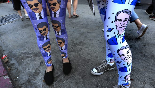 Protestors wear tights with portraits of scientists Neil deGrassse Tyson, left, and Bill Nye, right, as they  joined demonstrators at the March for Science rally in downtown Los Angeles.