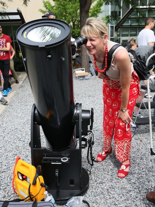 Debra Revolinski of Wind Lake looks at the eclipse through one of the telescopes at the event.