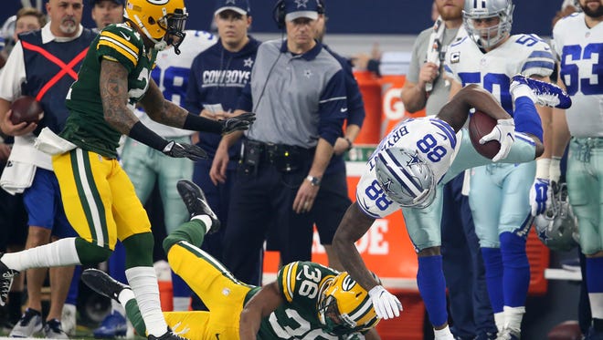 Dallas Cowboys wide receiver Dez Bryant (88) is tackled by Green Bay Packers cornerback LaDarius Gunter (36) during the first quarter in the NFC Divisional playoff game at AT&T Stadium.