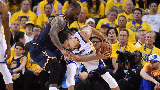 Golden State Warriors guard Stephen Curry (30) handles the ball against Cleveland Cavaliers forward LeBron James (23) during the second quarter in game one of the NBA Finals at Oracle Arena.