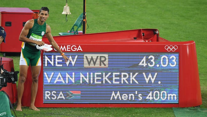 Wayde Van Niekerk (RSA) poses with the sign after setting a world record during the men's 400m final in the Rio 2016 Summer Olympic Games at Estadio Olimpico Joao Havelange.