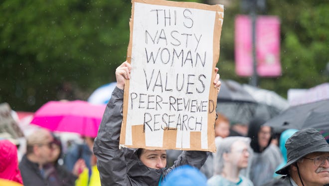 A woman carries a homemade sign for the March for Science in Washington.