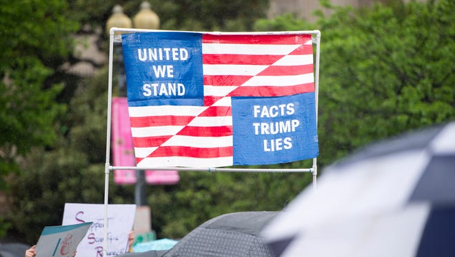 Marchers carry an American flag sign for the March for Science in Washington.