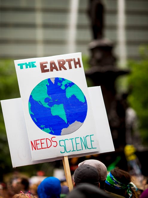 A participant holds a sign in Fountain Square in downtown Cincinnati to March for Science.