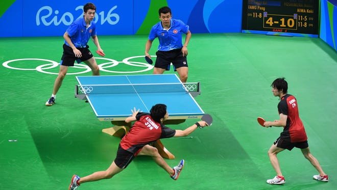 Peng Tang (HKG) and Kwan Kit Ho (HKG) take on Koki Niwa (JPN) and Maharu Yoshimura (JPN) in a men's team table tennis match at Riocentro - Pavilion 3 during the Rio 2016 Summer Olympic Games.