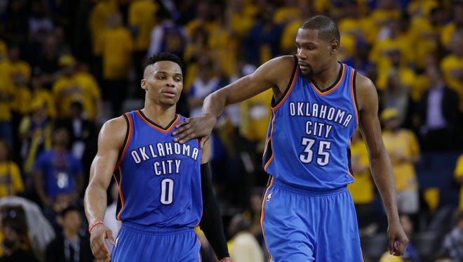 Oklahoma City Thunder's Kevin Durant (35) pats teammate Russell Westbrook (0) on the shoulder as they take a lead over the Golden State Warriors during the second half in Game 1 of the NBA basketball Western Conference finals Monday, May 16, 2016, in Oakland, Calif. Oklahoma City won 108-102. (AP Photo/Marcio Jose Sanchez)  ORG XMIT: OAS214