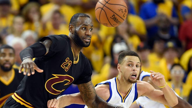 Cleveland Cavaliers forward LeBron James (23) and Golden State Warriors guard Stephen Curry (30) go after a loose ball during the third quarter in game seven of the NBA Finals at Oracle Arena.