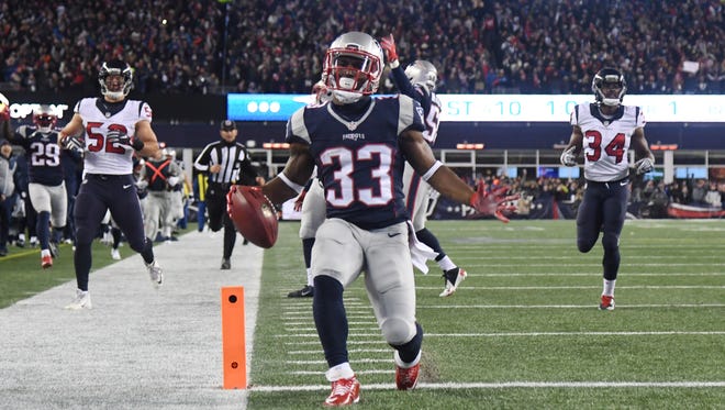New England Patriots running back Dion Lewis (33)returns a kick for a touchdown against the Houston Texans during the first quarter in the AFC Divisional playoff game at Gillette Stadium.