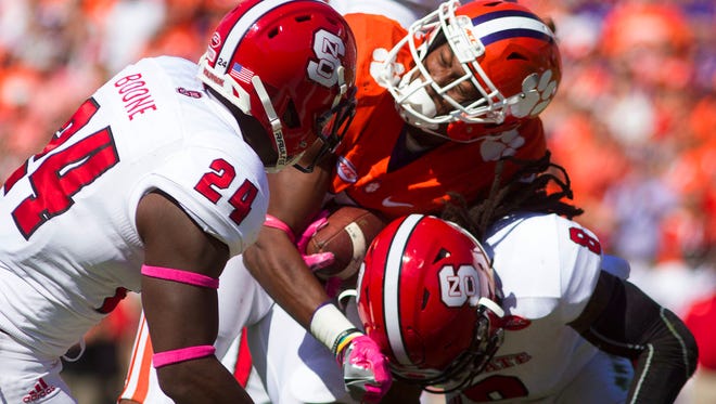 Clemson running back Wayne Gallman fumbles the ball while being brought down by North Carolina State defensive back Dravious Wright.