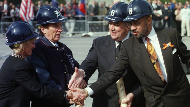 Detroit Mayor Dennis Archer and Gov. John Engler shake the hands with Marian and Mike Ilitch during groundbreaking ceremonies at the site of the new Tigers stadium in Detroit, Wednesday, Oct. 29, 1997.