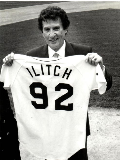 Mike Ilitch holds up his new uniform when he took the field as Tiger Stadium as the team's new owner.