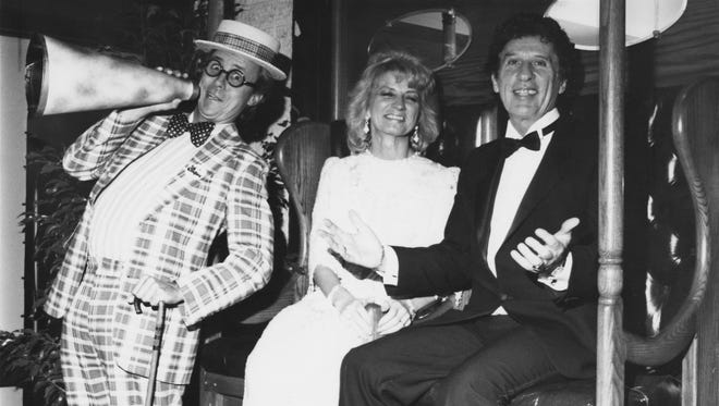Marian and Mike Ilitch are entertained by Stan Baker of le Cirque, a New York theatrical troupe at a Diabetes fundraiser held in October of 1988.