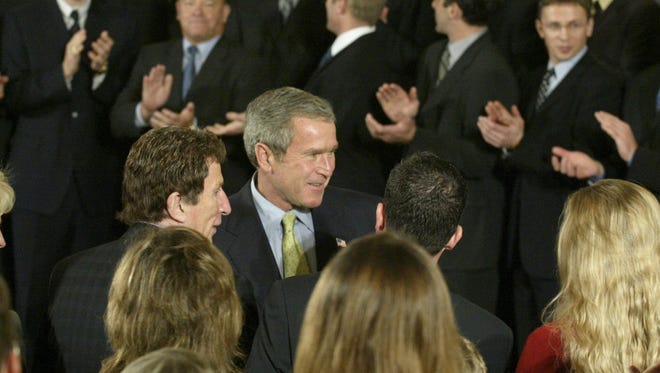 President Goerge W. Bush , bottom center, greets the Ilitch Family, Mike Ilitch bottom left center, during the Wings trip to the the White House on Fri Nov 28, 2002.