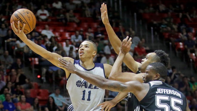 Utah Jazz guard Dante Exum (11) lays the ball in as San Antonio Spurs' Derrick White, rear, and Cory Jefferson (55) defend during the first half of an NBA Summer League game in Salt Lake City.