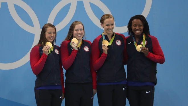 From left to right: Kathleen Baker, Lilly King, Dana Vollmer and Simone Manuel celebrate with their gold medals after winning the 4x100 medley relay. It was also the United States' 1,000th Summer Olympics gold medal.