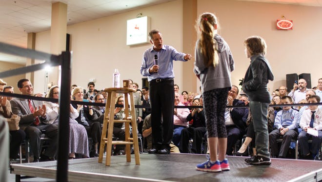 Brother and sister Declan and Sagel McGinley stand on stage with Kasich during a town hall event at the Antique Automobile Club of America Museum on April 1, 2016, in Hershey, Pa.