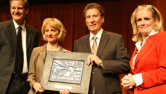 Marian and Mike Ilitch receive the Shining Light award in 2007. Presenting the award are Thomas W.B. Porter and Deborah Dingell.